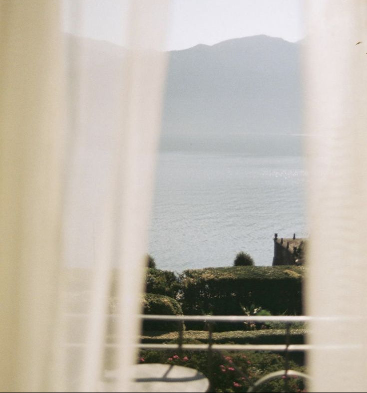 View of a mountain range from behind white curtains